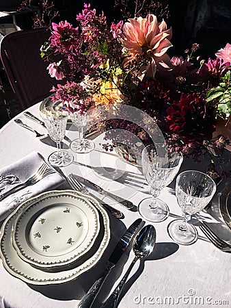 Outdoor catering dinner. Floral design. Vintage glasses and tableware. Romantic table setting with white tablecloth. bouquet Stock Photo