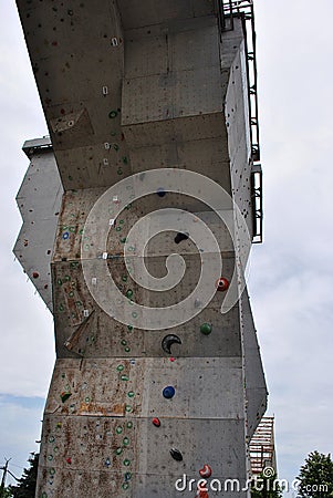 Outdoor construction, wall for training rock climbing, close up detail, gray rainy cloudy sky Stock Photo