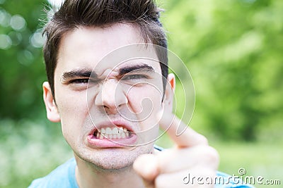 Outdoor Head And Shoulders Portrait Of Angry Young Man Stock Photo