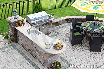 Outdoor kitchen and dining table on a paved patio Stock Photo