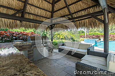 Outdoor tiki hut with outdoor grill kitchen and pool Stock Photo