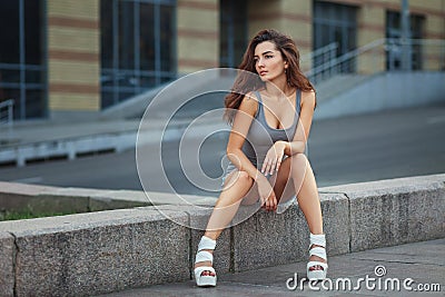 Outdoor lifestyle portrait of pretty young girl posing on stairway, wearing in hipster urban style on urban background Stock Photo