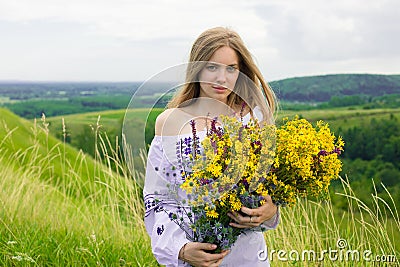 Outdoor portrait of beautiful blonde woman, attractive young girl in camomile field with flowers. Young beautiful girl in the fiel Stock Photo