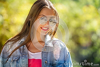 Outdoor portrait of beautiful, emotional, young woman in sunglasses. Soft background. Copy space Stock Photo