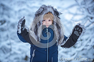 Outdoor portrait of cute baby kid in cold sunny winter weather in park. Little child in snow field. Winter portrait of Stock Photo