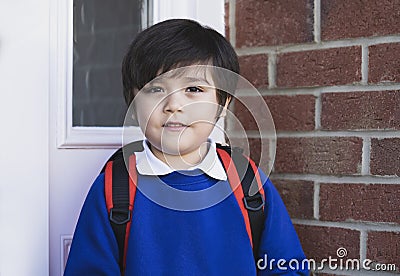 Outdoor portrait of happy child boy with backpack, Head shot of School kid wearing uniform,Pupil of primary going to school,Young Stock Photo