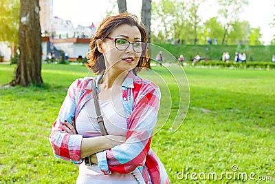 Outdoor portrait middle aged woman. Background city park Stock Photo