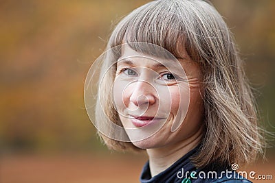 Outdoor portrait of smiling middle aged woman Stock Photo