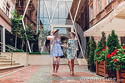 Outdoor portrait of two young beautiful women walking on city street. Best friends hanging, having fun Stock Photo