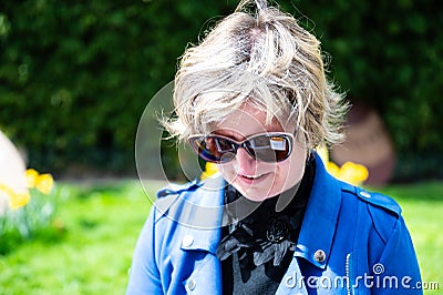 Outdoor portrait of a 39 yo white woman with a blue jacket and sunglasses, Koekelberg, Brussels, Belgium Stock Photo