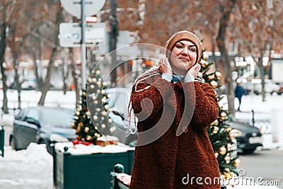 Outdoor portrait of young beautiful happy smiling woman posing on street. winter holidays concept Stock Photo