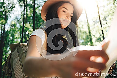 Outdoor portrait young brave traveler girl with traveling backpack hold location map in hand Stock Photo