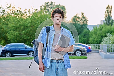Outdoor portrait of young male college student with backpack, laptop Stock Photo