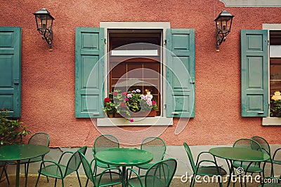 Outdoor restaurant tables over building wall background. Old European city urban detail. Retro filter Stock Photo