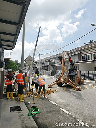 Outdoor scene of workers digging and piling concrete pole preparation for 5G cable connection Editorial Stock Photo