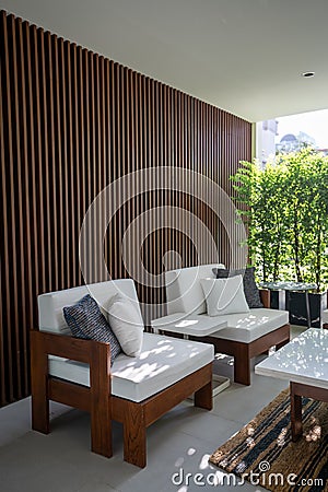 Outdoor seating corner with wood batten background in tree shade /interior design / outdoor space / copy space Stock Photo