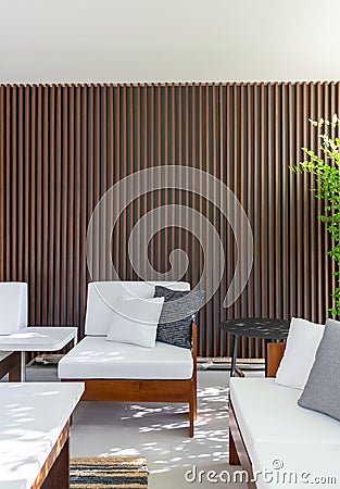 Outdoor seating corner with wood batten background in tree shade /interior design / outdoor space / copy space Stock Photo