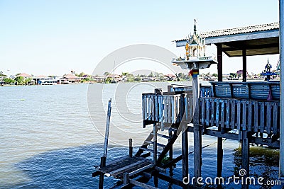 Outdoor spirit house on riverside local terrace in Thailand with garland and flowers in vases and some wreathes, joss house Stock Photo