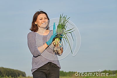 Outdoor spring portrait of mature woman with fresh green onions Stock Photo