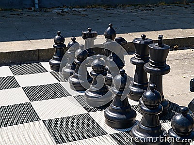 Outdoor street chess board with big black plastic pieces Stock Photo