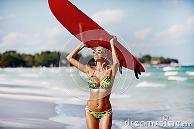 Outdoor summer portrait of slim beautiful woman with surfboard on a sunny beach Stock Photo