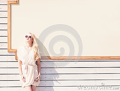 Outdoor summer sensual fashion portrait beautiful young blond woman of a white dress in sunglasses on the street on the background Stock Photo