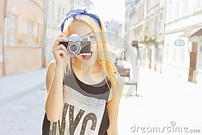 Outdoor summer smiling lifestyle portrait of pretty young woman having fun in the city in Europe with camera. Travel photo of phot Stock Photo