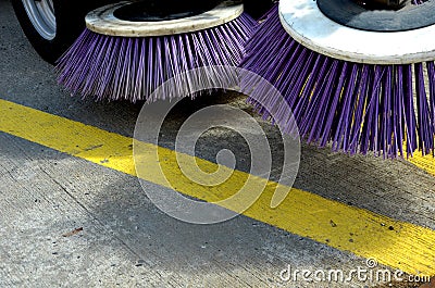 Outdoor sweeper. using round brushes with plastic purple brushes. Cleaning gravel and clutter in the city streets after constructi Stock Photo