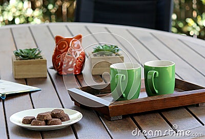 Outdoor table setting with cookies, two coffee cups, book, flowers Stock Photo