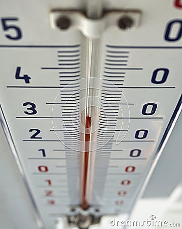 Outdoor thermometer with the retro design displaying high temperature of thirty degrees of Celsius Stock Photo