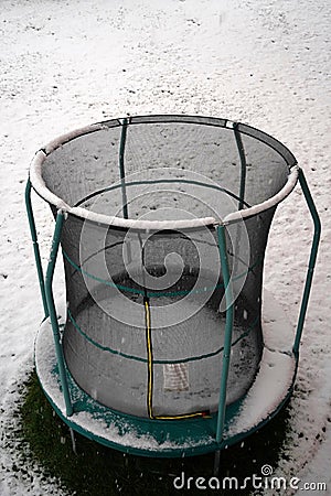 Outdoor trampoline in winter on a snow covered meadow. It can have symbolic or metaphoric meaning. Stock Photo