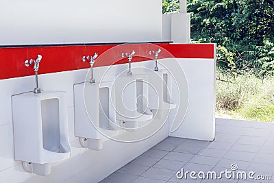 Outdoor urinal toilet old white and red color, the toilet of man with toilet view by urinals outdoors Stock Photo
