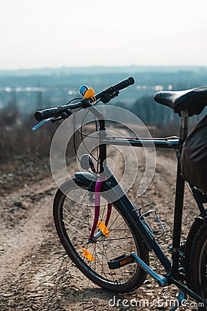 Outdoor view on classic bicycle detail. hilltop overlooking a valley in haze, a city on the horizon. winter or autumn landscape Stock Photo