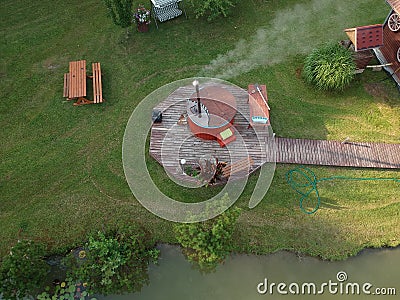 Outdoor wooden barrel bath in summer homestead, aerial Stock Photo