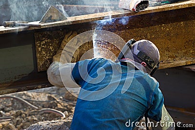 Outdoor worker with protective mask welding metal and sparks Stock Photo