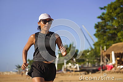 Outdoors fitness lifestyle portrait of young attractive and athletic woman in compression running socks jogging on the beach doing Stock Photo