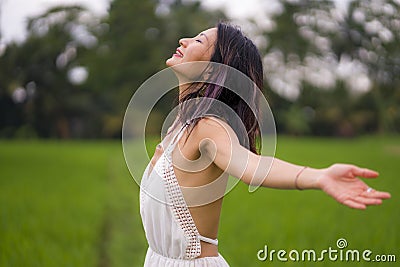 Outdoors holidays portrait of attractive and happy middle aged Asian Chinese woman in white dress enjoying freedom and nature at Stock Photo