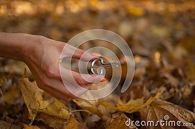 Outdoors photo of traditional hutsul drymba, jaw`s harp, silver vargan in female hand on fallen leaves background during Stock Photo