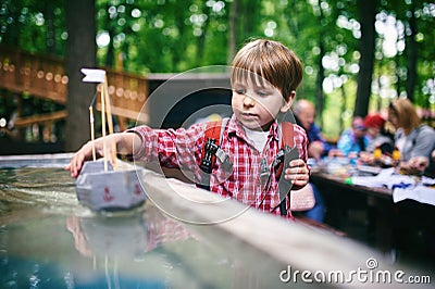 Outdoors portrait of cute preschool boy playing homemade ship in the park Stock Photo