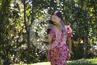 Outdoors Summer lifestyle portrait of young beautiful and happy Asian Chinese woman in elegant dress walking tranquil and cheerful Stock Photo
