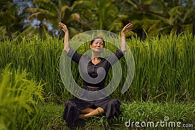 Outdoors yoga and meditation at rice field - attractive and happy middle aged Asian Korean woman enjoying yoga and relaxation in Stock Photo