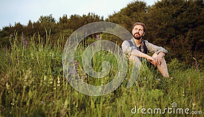 Outdoorsman sitting grass enjoying nature Stock Photo