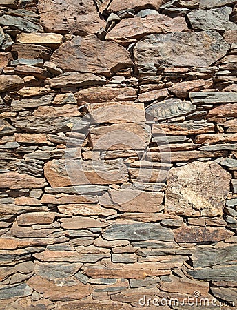 Outer wall of a house made of flat red rock Stock Photo