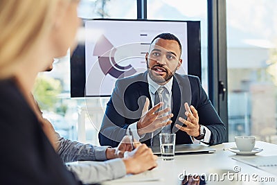 Outlining the goal for their meeting. a group of young businesspeople having a meeting in the boardroom of a modern Stock Photo