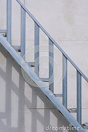 Outside steel staircase structure on gray smartboard wall background in house construction site Stock Photo