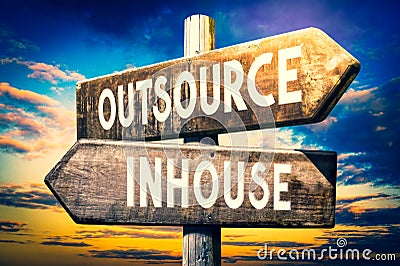 Outsource, inhouse - wooden signpost, roadsign with two arrows Stock Photo