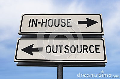 Outsource versus in-house road sign with two arrows on blue sky background. White two streets sign with arrows on metal pole. Stock Photo