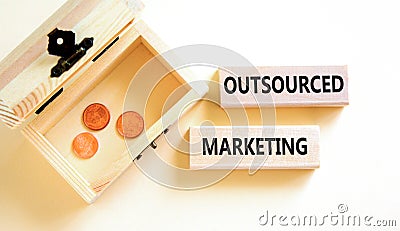 Outsourced marketing symbol. Concept words Outsourced marketing on beautiful wooden blocks. Beautiful white table white background Stock Photo