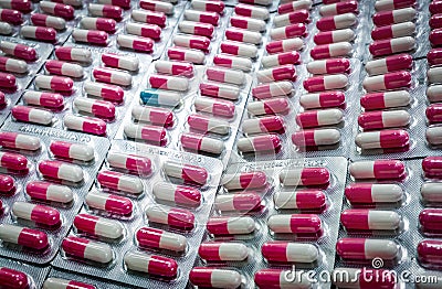 Outstanding blue-white capsule in many of pink-white antibiotic capsule pills in blister pack. Antibiotic drug resistance. Stock Photo