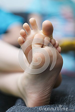 The outstretched and crossed legs of a child Stock Photo